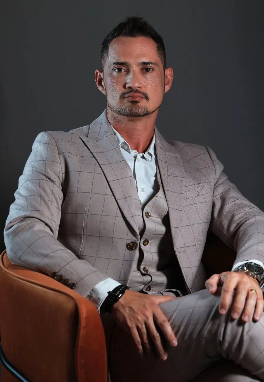 Dr. Sharbo Casagrande, de terno claro, sentado numa poltrona de couro